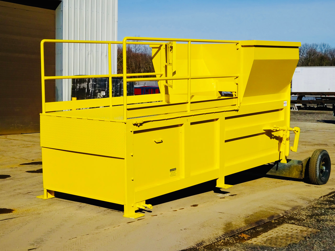 Stationary compactor with walk-on deck rear feed hopper, serviced by Stellar Waste
